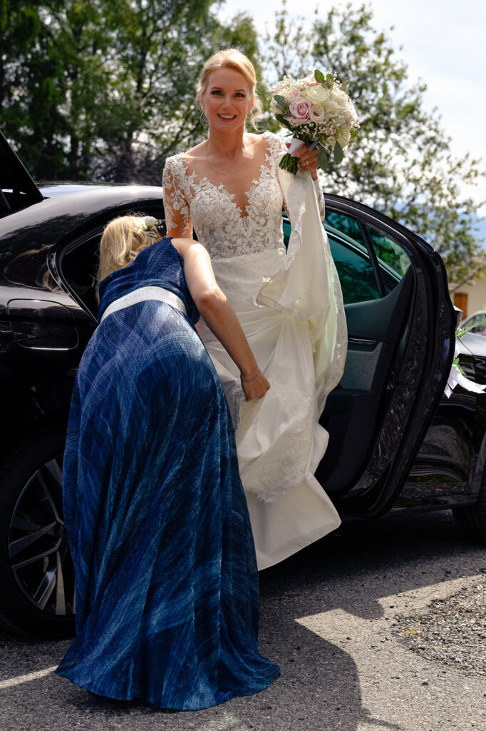 Mariée Éponine sortant de la voiture à son mariage au Plateau d’Assy Chamonix