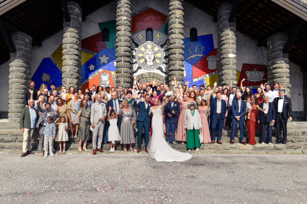 Photo de groupe du mariage d’Éponine et Martin devant l’église du Plateau d’Assy – Photographe mariage Chamonix