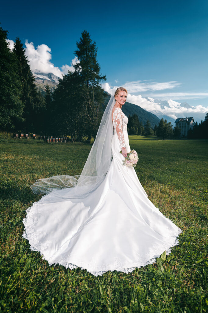 Mariée en robe blanche dans un champ avec vue sur le Mont Blanc – Photographe mariage Chamonix