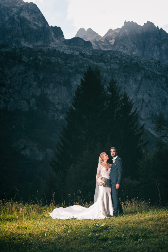 Mariés dans un champ avec les montagnes du Mont Blanc en arrière-plan – Photographe mariage Chamonix