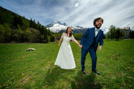 Couple de mariés en prairie alpine avec vue sur le Mont-Blanc, Argentière Chamonix