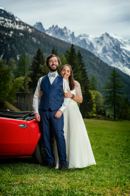 Couple de mariés en prairie alpine avec spider rouge et vue sur le Mont-Blanc, Argentière Chamonix