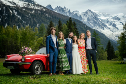 Couple de mariés en prairie alpine avec spider rouge et vue sur le Mont-Blanc, Argentière Chamonix